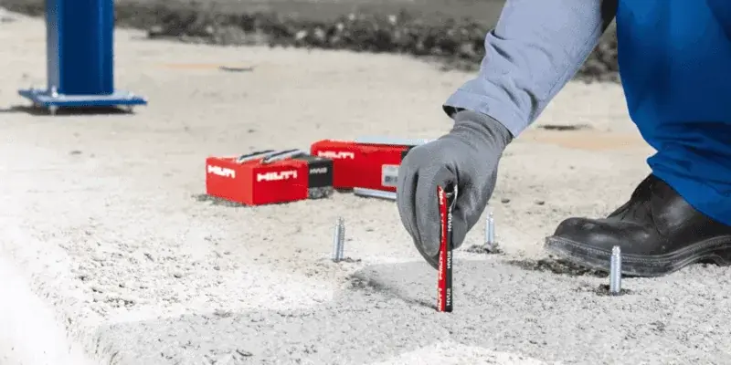 ช่างสวมถุงมือกำลังติดตั้งพุกเคมี HILTI ลงในรูเจาะบนพื้นคอนกรีต