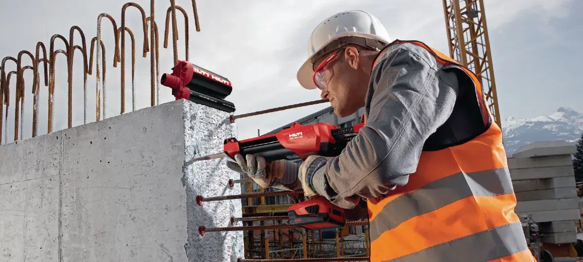 ช่างกำลังใช้ระบบน้ำยาเคมี HILTI เจาะเสียบเหล็กเข้ากับโครงสร้างคอนกรีตในหน้างานก่อสร้าง